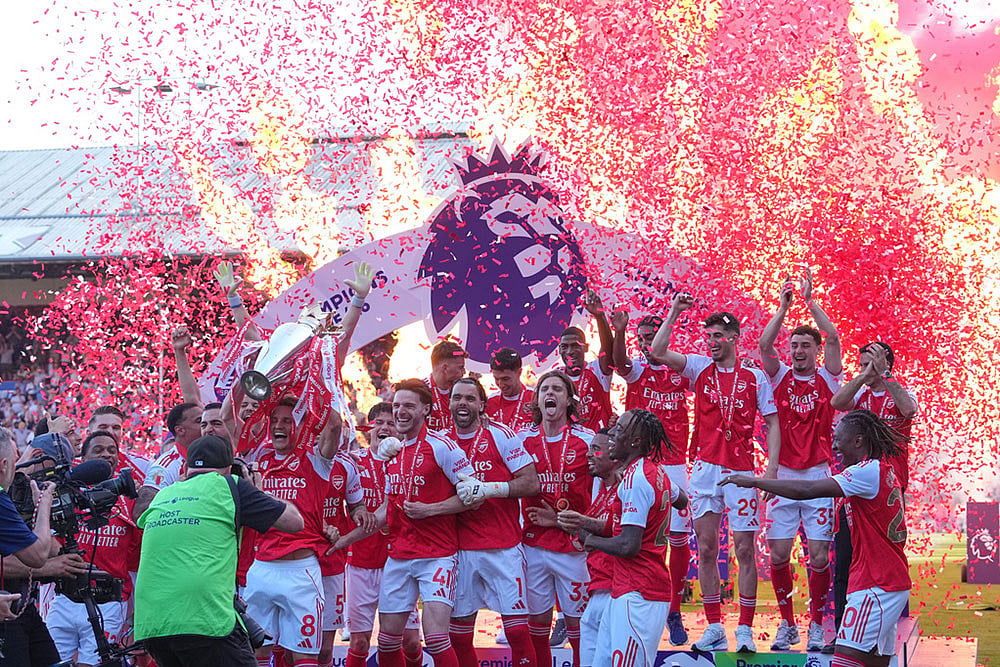 Arsenal players celebrate their Premier League title with the trophy after the English Premier League soccer match between Crystal Palace and Arsenal in London, England. - | Photo: AP/Kin Cheung