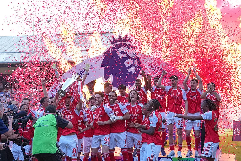 Arsenal players celebrate their Premier League title with the trophy after the English Premier League soccer match between Crystal Palace and Arsenal in London, England. - | Photo: AP/Kin Cheung