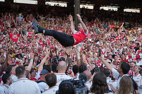 Arsenal's manager Mikel Arteta is thrown in the air by the players celebrating their Premier League title after the English Premier League soccer match between Crystal Palace and Arsenal in London, England.