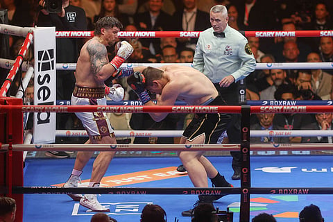 Oleksandr Usyk, left, fights during a boxing match against Rico Verhoeven, right, at the WBC World Heavyweight Championship "Glory in Giza" at the site of the Pyramids of Giza, in Giza, Egypt.
