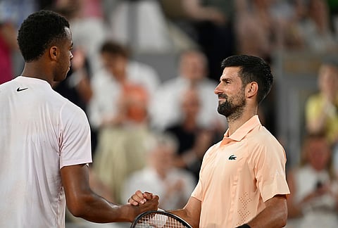 Novak Djokovic of Serbia, right, and Giovanni Mpetshi Perricard shake hands after their first round men's singles tennis match of France at the French Open tennis tournament in Paris.