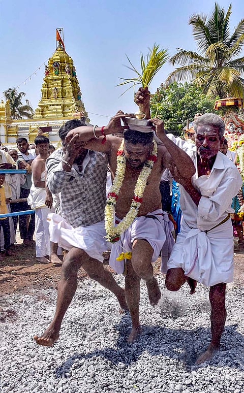 Devotees walk across burning embers during the Pete Kollapuradamma Kendotsava festival, in Chikkamagaluru, Karnataka.