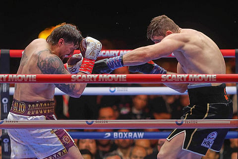 Oleksandr Usyk, left, fights during a boxing match against Rico Verhoeven, right, at the WBC World Heavyweight Championship "Glory in Giza" at the site of the Pyramids of Giza, in Giza, Egypt.