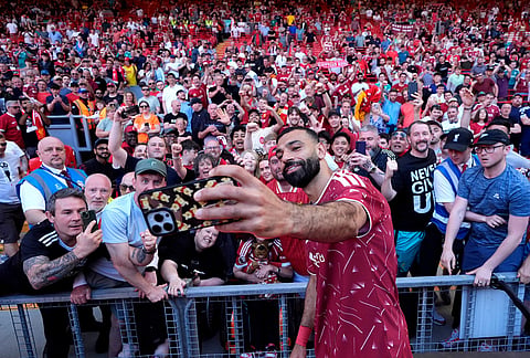 Liverpool's Mohamed Salah takes a selfie with fans following his final Liverpool appearance in the Premier League match at Anfield, Liverpool, England.