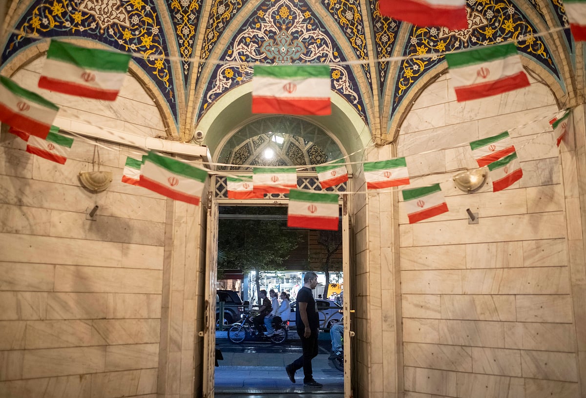Daily Life In Iran Amid Threat About New Possible War An Iranian man walks past a mosque decorated with national flags in a business district in downtown Tehran, Iran. - IMAGO