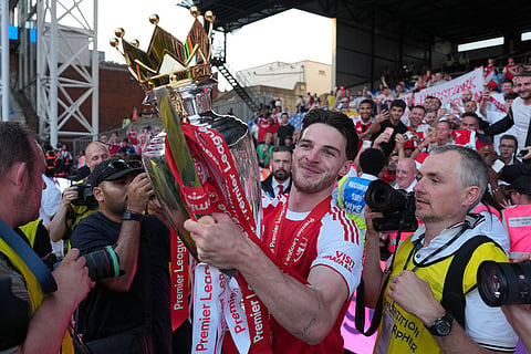 Arsenal's Declan Rice celebrates their Premier League title with the trophy after the English Premier League soccer match between Crystal Palace and Arsenal in London, England.