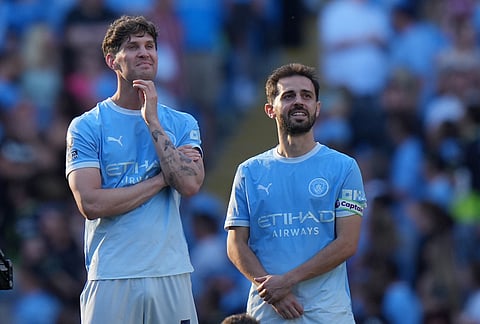 Manchester City's John Stones, left, and Bernardo Silva attand a farawell cerony after they both had their last game for the club after a Premier League soccer match between Manchester City and Aston Villa in Manchester, England.