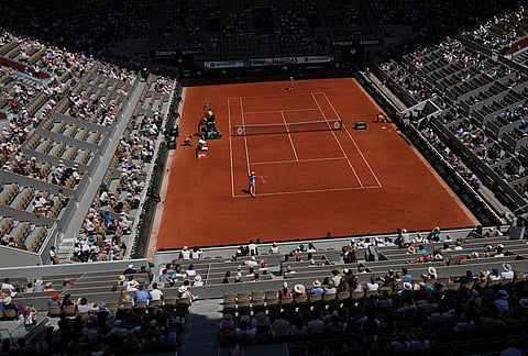 Iga Swiatek of Poland, bottom, returns to Emerson Jones of Australia during their first round women's singles tennis match at the French Open tennis tournament in Paris.