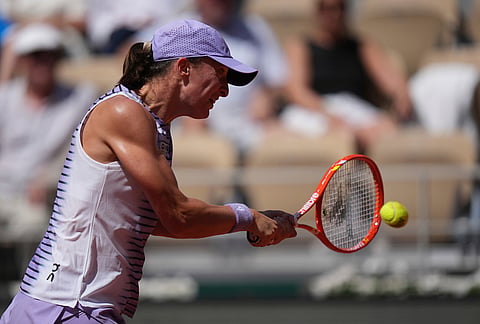 Iga Swiatek of Poland returns to Emerson Jones of Australia during their first round women's singles tennis match at the French Open tennis tournament in Paris.