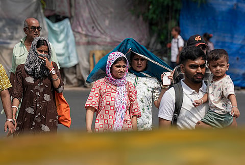 People cover themselves on a hot summer day, in Kolkata, West Bengal.