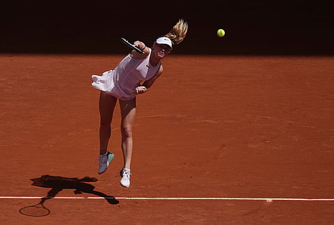 Emerson Jones of Australia serves to Iga Swiatek of Poland during their first round women's singles tennis match at the French Open tennis tournament in Paris.