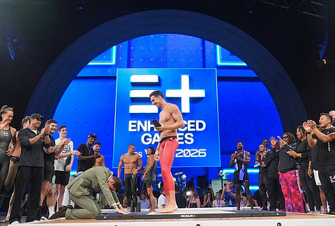Enhanced Games CEO Maximilian Martin bows before swimmer Kristian Gkolomeev, of Greece, during an award ceremony at the Enhanced Games in Las Vegas.