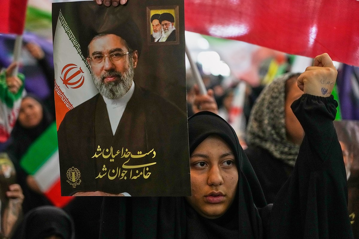 A woman holds a portrait of Iran's Supreme Leader, Ayatollah Mojtaba Khamenei, during a ceremony honoring the armed forces and those killed in the war with Israel and the U.S. at the Imam Khomeini Grand Mosque in Tehran, Iran. - PTI