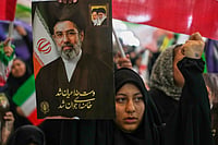 Iran’s Supreme Leader Declares Middle East ‘Will No Longer Serve as Shields’ for US Bases Amid Fragile Ceasefire bases PTI : A woman holds a portrait of Iran's Supreme Leader, Ayatollah Mojtaba Khamenei, during a ceremony honoring the armed forces and those killed in the war with Israel and the U.S. at the Imam Khomeini Grand Mosque in Tehran, Iran.