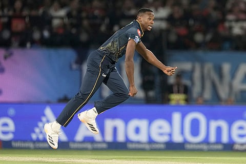 Gujarat Titans' Kagiso Rabada bowls a delivery during the Indian Premier League cricket match between Gujarat Titans and Royal Challengers Bengaluru in Dharamshala, India.