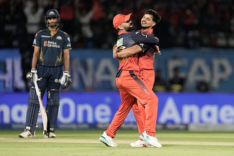 Royal Challengers Bengaluru's Rasikh Dar, right, celebrates with teammate Virat Kohli after the dismissal of Gujarat Titans' Nishant Sindhu during the Indian Premier League cricket match between Gujarat Titans and Royal Challengers Bengaluru in Dharamshala, India.
