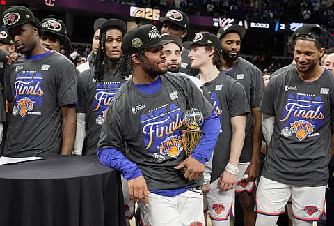 New York Knicks guard Jalen Brunson, center, holds the MVP trophy after Game 4 in the Eastern Conference finals NBA basketball playoffs series against the Cleveland Cavaliers in Cleveland.