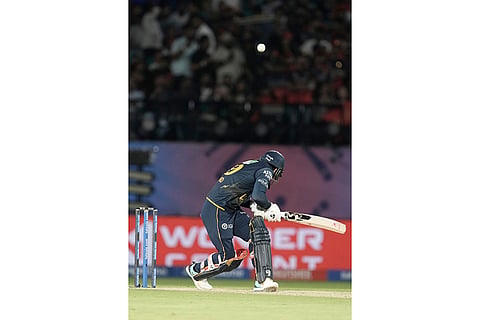 Gujarat Titans' Rashid Khan bends to avoid a bouncer from Royal Challengers Bengaluru's Jacob Duffy during the Indian Premier League cricket match between Gujarat Titans and Royal Challengers Bengaluru in Dharamshala, India.