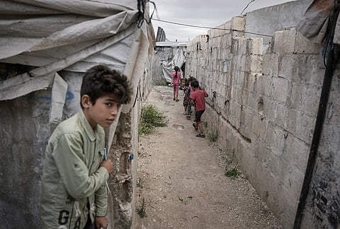 Children play through al-Karama camp, established in the early years of the Syrian conflict and built from scratch with light-brick structures covered with fabric to house internally displaced Syrians near the village of Atmeh, Idlib province, Syria.