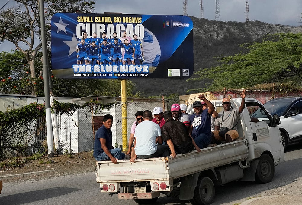 Commuters drive past a billboard displaying the Curacao national soccer team in Willemstad, Curacao.