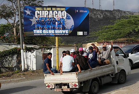 Commuters drive past a billboard displaying the Curacao national soccer team in Willemstad, Curacao.