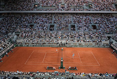 Jannik Sinner of Italy, right, returns to Clement Tabur of France during their first round men's singles tennis match at the French Open tennis tournament in Paris.