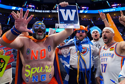 "Thundor" Garrett Havil, second from left, cheers with other fans as the Oklahoma City Thunder defeats the San Antonio Spurs after of Game 5 in the Western Conference finals NBA basketball playoffs series, in Oklahoma City. 