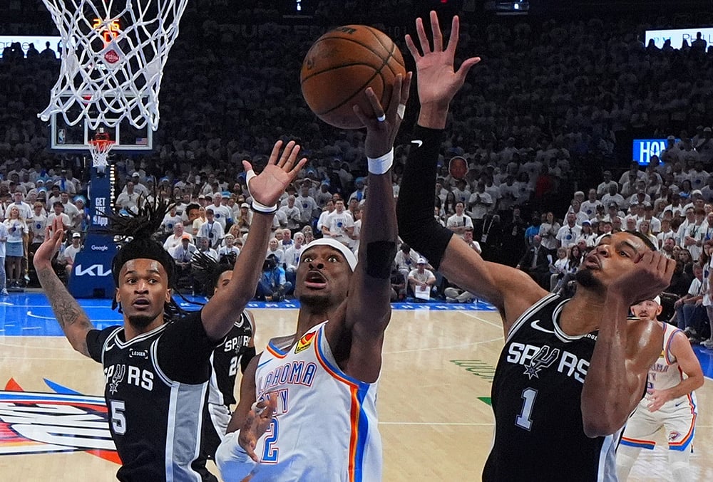 Oklahoma City Thunder guard Shai Gilgeous-Alexander (2) shoots against San Antonio Spurs forward Victor Wembanyama (1) in the second half of Game 5 in the Western Conference finals NBA basketball playoffs series in Oklahoma City.  - | Photo: AP/Julio Cortez