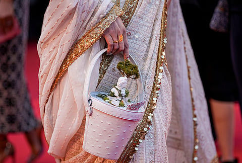 A woman walks on the red carpet holding a zen-garden inspired purse upon arrival at the premiere of the film 'Paper Tiger' at the 79th international film festival, Cannes, southern France.