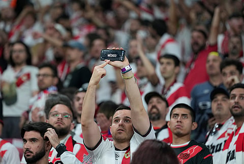 A fan of Rayo uses his phone to call for a doctor to come to the stands during the Europa Conference League final soccer match between Crystal Palace and Rayo Vallecano in Leipzig, Germany.