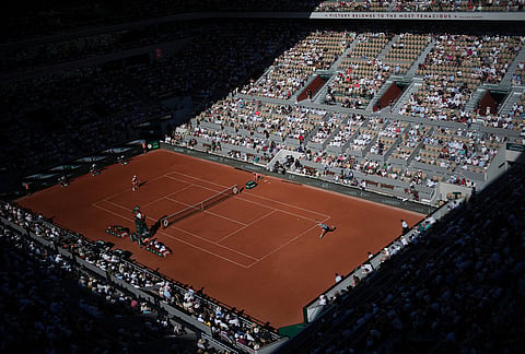 Valentin Royer of France, right, returns to Novak Djokovic of Serbia during their second round men's singles tennis match at the French Open tennis tournament in Paris.