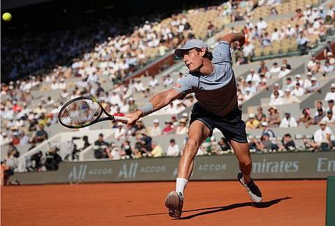 Valentin Royer of France returns to Novak Djokovic of Serbia during their second round men's singles tennis match at the French Open tennis tournament in Paris.