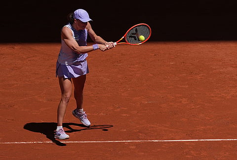 Iga Swiatek of Poland returns to Sara Bejlek of the Czech Republic during their second round women's singles tennis match at the French Open tennis tournament in Paris.