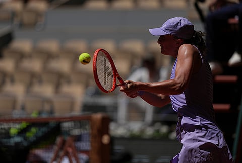 Iga Swiatek of Poland returns to Sara Bejlek of the Czech Republic during their second round women's singles tennis match at the French Open tennis tournament in Paris.