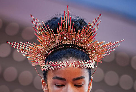 A woman wearing an intricate tiara walks on the red carpet at the premiere of the film 'The Birthday Party' at the 79th international film festival, Cannes, southern France.