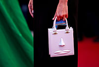 Cannes 2026: Playful And Extravagant Fashion Details That Turned Heads On The Red Carpet - In Photos | Photo: AP/Andreea Alexandru : A woman holding a purse decorated with a depiction of a face poses for photographers upon arrival at the premiere of the film 'Hope' at the 79th international film festival, Cannes, southern France.