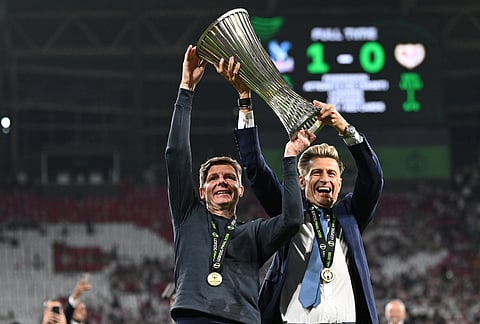 Crystal Palace's head coach Oliver Glasner, left, and Palace owner Steve Parish hold the trophy after winning the Europa Conference League final soccer match between Crystal Palace and Rayo Vallecano in Leipzig, Germany.