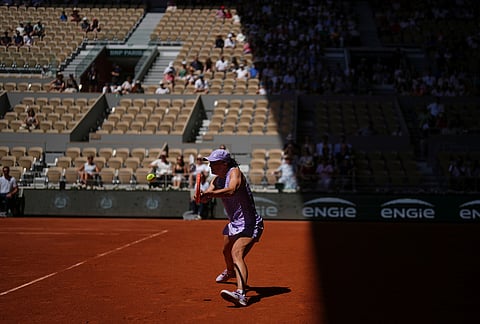 Iga Swiatek of Poland returns to Sara Bejlek of the Czech Republic during their second round women's singles tennis match at the French Open tennis tournament in Paris.