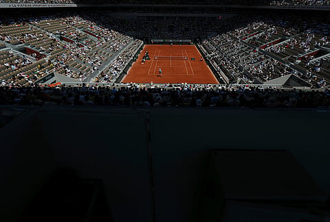 Jannik Sinner of Italy, bottom returns to Juan Manuel Cerundolo of Argentina during their second round men's singles tennis match at the French Open tennis tournament in Paris.