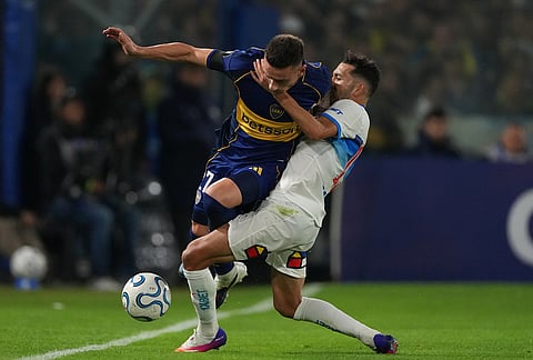 Malcom Braida of Argentina's Boca Juniors, left, and Cristian Cuevas of Chile's Universidad Catolica battle for the ball during a Copa Libertadores Group D soccer match in Buenos Aires, Argentina.