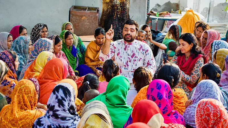 Man speaking to a group of seated women
