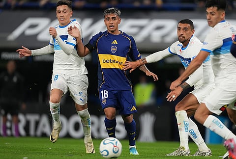 Milton Delgado of Argentina's Boca Juniors, center, battles for the ball with Fernando Zuqui, left, and Cristian Cuevas of Chile's Universidad Catolica, second from right, during a Copa Libertadores Group D soccer match in Buenos Aires, Argentina.