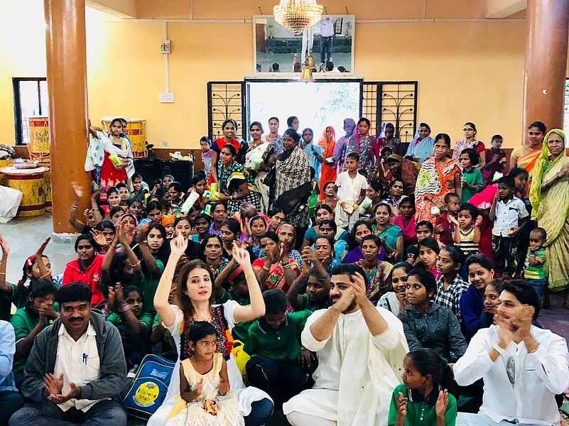 Large group gathering of people clapping inside a community hall
