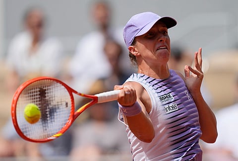 Iga Swiatek of Poland returns to Magda Linette of Poland during their third round women's singles tennis match at the French Open tennis tournament in Paris.