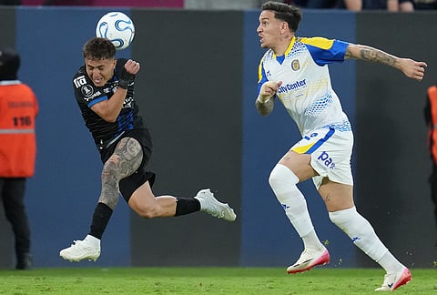 Layan Loor of Ecuador's Independiente del Valle, left, heads the ball as Enzo Copetti of Argentina's Rosario Central, right, looks on during a Copa Libertadores Group H soccer match in Quito, Ecuador.