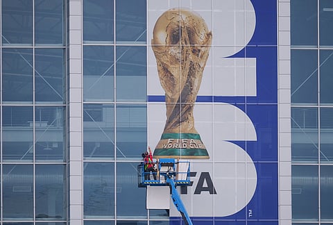 A worker installs signage on the glass of AT&T Stadium, which will be named Dallas Stadium during the 2026 FIFA World Cup, as preparations continue at the venue ahead of the soccer tournament, in Arlington, Texas. 