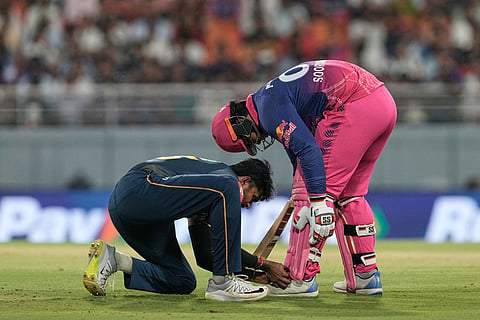 Gujarat Titans' Sai Sudharsan ties the laces of Rajasthan Royals' Vaibhav Sooryavanshi during the Indian Premier League cricket match between Gujarat Titans and Rajasthan Royals in New Chandigarh, India.