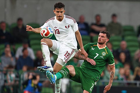 Qatar's Ayoub Al-Oui, left, challenges for the ball with Ireland's Troy Parrott during the international friendly soccer match between Ireland and Qatar in Dublin, Ireland.