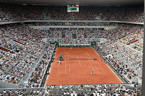 Joao Fonseca of Brazil, bottom, returns to Novak Djokovic of Serbia during their third round men's singles tennis match at the French Open tennis tournament in Paris.