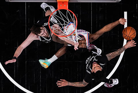 Oklahoma City Thunder guard Cason Wallace (22) shoots against San Antonio Spurs forward Julian Champagnie (30) in the second half of Game 6 in the Western Conference finals NBA basketball playoffs series, in San Antonio. 